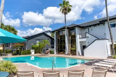 a swimming pool with chairs and a building at Legacy Vacation Resorts - Disney and Lake Buena Vista in Orlando