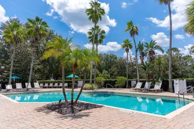 a pool with palm trees and lounge chairs at Legacy Vacation Resorts - Disney and Lake Buena Vista in Orlando