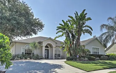 a house with palm trees in the driveway at 4 Mi to Disney Kissimmee Group Getaway in Orlando