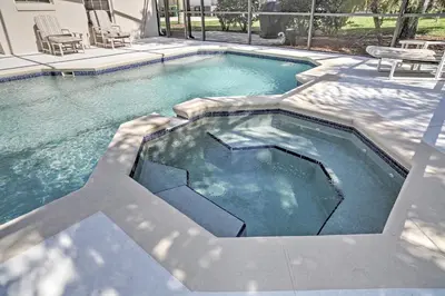 a large swimming pool in a yard with two chairs at 4 Mi to Disney Kissimmee Group Getaway in Orlando