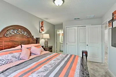 a bedroom with a large bed with a wooden headboard at Theme Park Retreat with 5-Star Amenities - By Disney in Kissimmee