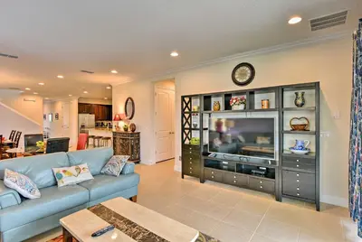 a living room with a blue couch and a tv at 5 Mi to Disney Oasis with Pool and Patio in Orlando