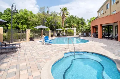 a pool at a resort with tables and chairs at Fairfield Inn & Suites Orlando Ocoee in Orlando