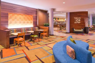 a lobby of a hotel with tables and chairs at Fairfield Inn & Suites Orlando Ocoee in Orlando
