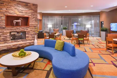 a lobby with a blue couch and a fireplace at Fairfield Inn & Suites Orlando Ocoee in Orlando