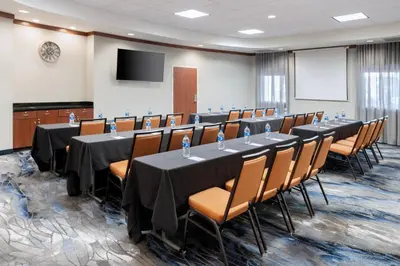 a conference room with tables and chairs and a screen at Fairfield Inn & Suites Orlando Ocoee in Orlando