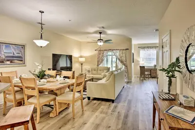 a dining room and living room with a table and chairs at Kissimmee Retreat with Pool Access Less Than 4 Mi to Disney! in Orlando