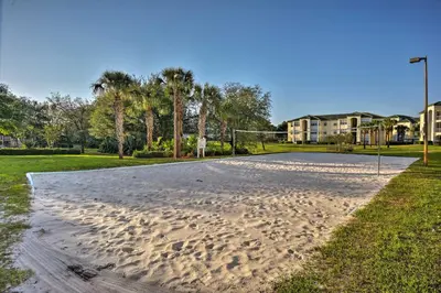an empty volleyball court in a park with palm trees at Lovely Resort Condo Near Disney, Golf and Dining! in Kissimmee