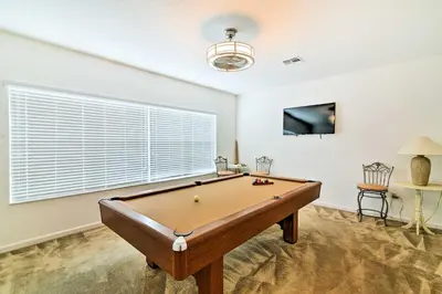 a pool table in a room with a window at Home with Private Pool and Spa 8 Mi to Disney in Kissimmee