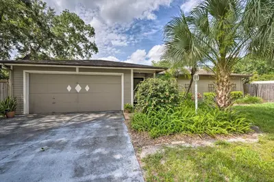 a house with a garage and a palm tree at Pet-Friendly Apopka Home 30 Mi to WDW! in Orlando