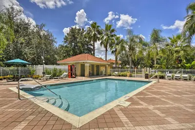 a swimming pool in a courtyard with palm trees at 5 Mi to Disney Emerald Island Resort Condo! in Kissimmee