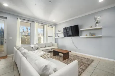 a living room with a white couch and a table at 4 Mi to Dtwn Home with Pool Access in Sanford in Sanford