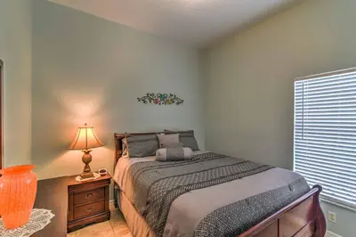 a bedroom with a bed and a lamp and a window at Kissimmee Retreat with Pool Near Disney and Golf! in Kissimmee