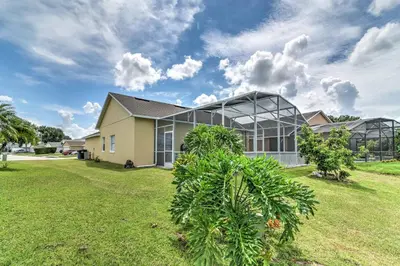 a house with a green yard in front of it at Kissimmee Retreat with Pool Near Disney and Golf! in Kissimmee