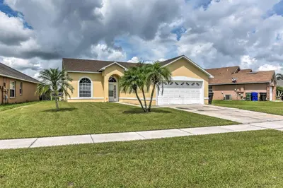 a house with palm trees in the front yard at Kissimmee Retreat with Pool Near Disney and Golf! in Kissimmee