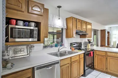 a kitchen with wooden cabinets and a stainless steel sink at Spacious Central Florida Home Family Friendly! in Orlando