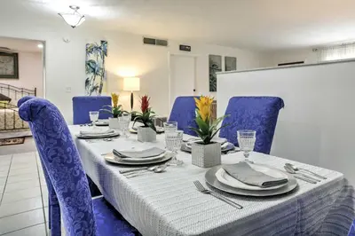 a dining room table with blue chairs and a white table cloth at Spacious Central Florida Home Family Friendly! in Orlando