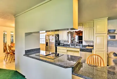 a kitchen with white cabinets and a black counter top at Sandford Vacation Rental Near Airport and Lake! in Sanford