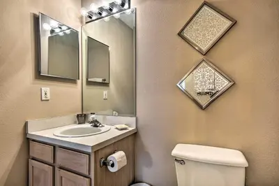 a bathroom with a sink and a toilet and a mirror at Clermont Home with Pool and Game Room 10 Mi to Parks! in Orlando