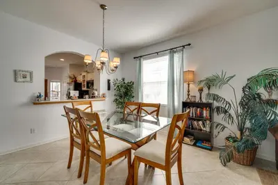 a dining room with a glass table and chairs at Spacious Home in Gated Resort, 2 Mi to Disney! in Orlando