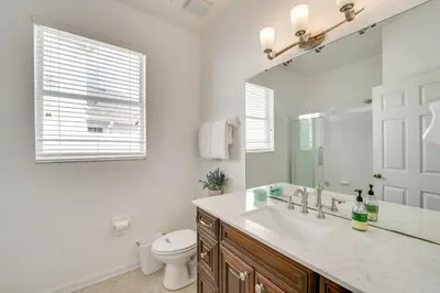 a bathroom with a sink and a toilet and a mirror at Spacious Home in Gated Resort, 2 Mi to Disney! in Orlando