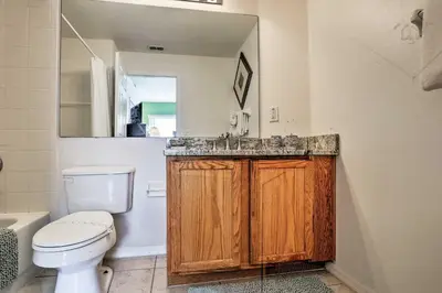 a bathroom with a toilet and a sink and a mirror at 5 Mi to Disney Parks Kissimmee Home with Game Room in Kissimmee