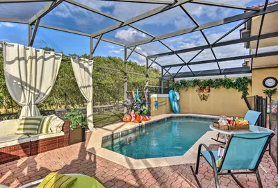 a patio with a pool and a table and chairs at 4 Mi to Animal Kingdom Gem with Pool in Kissimmee in Kissimmee
