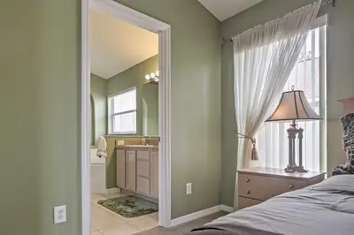 a bedroom with a bed and a sink and a mirror at Beautiful Kissimmee Home - 5 Mi to Disney World! in Kissimmee