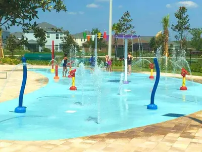 a water park with children playing in a fountain at Lovely 2BR Codo with 2Clubhouses & Kids Splash Pad in Kissimmee