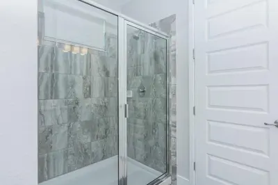 a shower with a glass door in a bathroom at Amazing Home w a Private Pool in Orlando