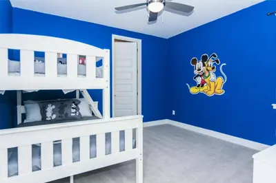 a bedroom with a blue wall with mickey mouse decal at Amazing Home w a Private Pool in Orlando