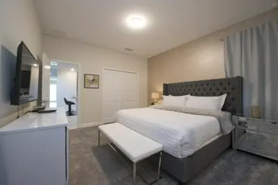 a bedroom with a large bed and a television at Gorgeous 5 Beds Home with Game Room and Pool in Kissimmee