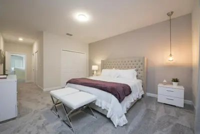 a bedroom with a large bed and a chair at Gorgeous 5 Beds Home with Game Room and Pool in Kissimmee