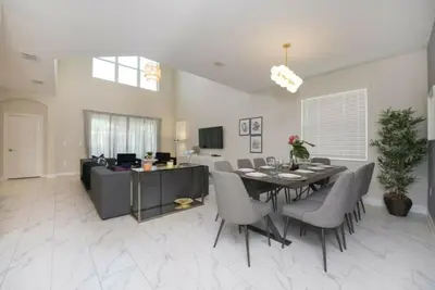 a dining room and living room with a table and chairs at Gorgeous 5 Beds Home with Game Room and Pool in Kissimmee