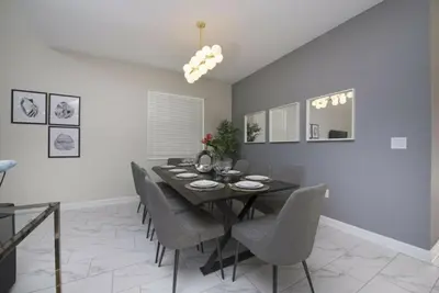 a dining room with a black table and chairs at Gorgeous 5 Beds Home with Game Room and Pool in Kissimmee