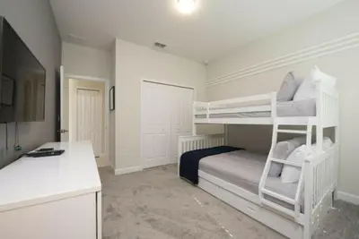 a bedroom with two bunk beds and a desk at Gorgeous 5 Beds Home with Game Room and Pool in Kissimmee