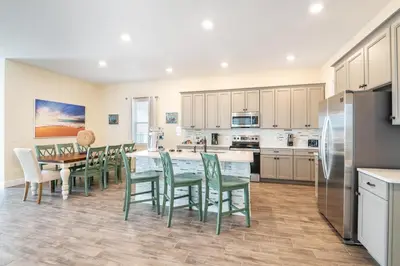 a kitchen with a table and chairs and a refrigerator at 3 Story Cottage With Private Pool Near Disney With Margaritaville Resort & Island H20 Access - 8105Su in Orlando