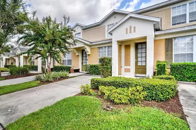 a house with bushes in front of it at Our Mickey Mouse House Townhome with Pool! in Orlando