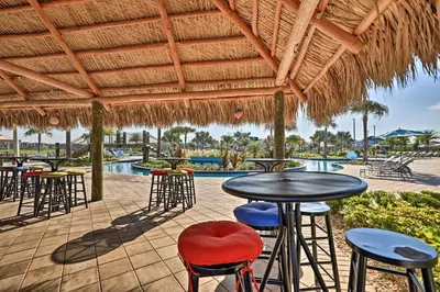 a patio with tables and chairs and a swimming pool at about 6 Mi to Disney Kissimmee Retreat with Pool! in Kissimmee