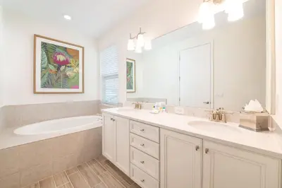 a bathroom with two sinks and a bath tub and a mirror at Sunset Sands Cottage Near Disney With Margaritaville Resort & Island H2O Access - 8065Dr in Orlando