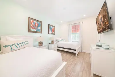 a white bedroom with a bed and a window at Sunset Sands Cottage Near Disney With Margaritaville Resort & Island H2O Access - 8065Dr in Orlando