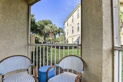 two chairs sitting on a balcony with a window at Lake-View Condo with Pool Access 6 Mi to Disney! in Kissimmee