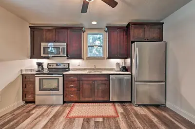 a kitchen with wooden cabinets and stainless steel appliances at Walkable Winter Garden Bungalow 3 Blocks to Dtwn in Orlando