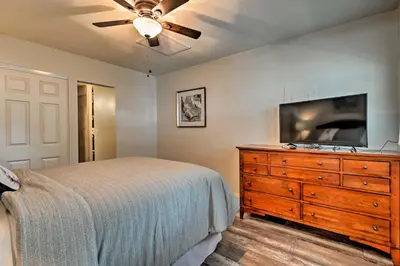 a bedroom with a bed and a dresser with a flat screen tv at Walkable Winter Garden Bungalow 3 Blocks to Dtwn in Orlando