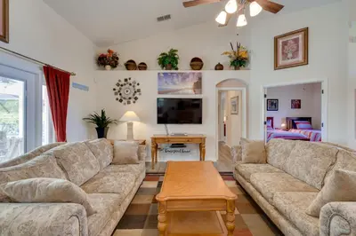 a living room with a couch and a table at 12 Mi to Disney Home with Pool and Spa in Clermont in Orlando