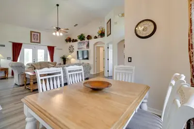 a dining room and living room with a wooden table at 12 Mi to Disney Home with Pool and Spa in Clermont in Orlando