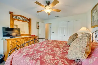 a bedroom with a bed and a flat screen tv at 12 Mi to Disney Home with Pool and Spa in Clermont in Orlando