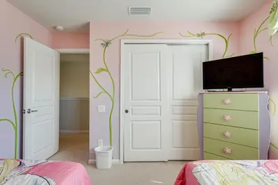 a bedroom with pink and green walls and a door at 3 Mi to WDW Windsor Hills Home with Game Room! in Orlando