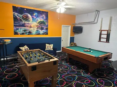 a room with a pool table and a painting at 7 Bedroom, 6 bath and pool near Disney in Emerald Island 4 King Master Suites in Kissimmee