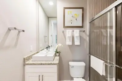 a white bathroom with a sink and a toilet at 5min Disney Wonderful Villa, BBQ, SMV102 in Orlando